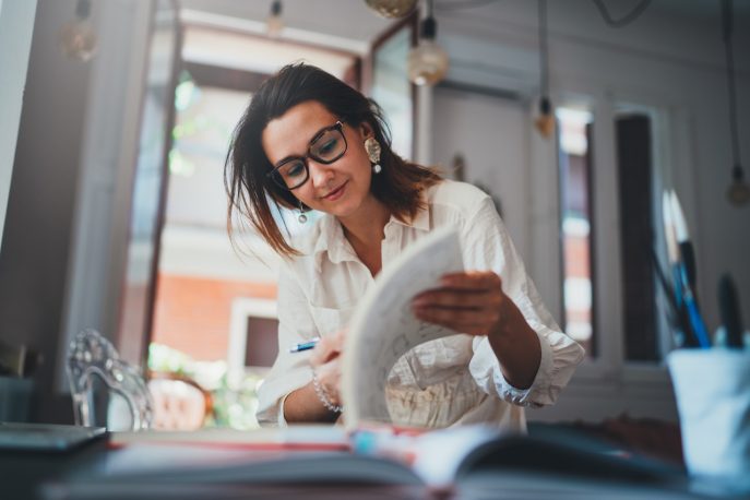 Woman creating a financial plan with notes and documents at home
