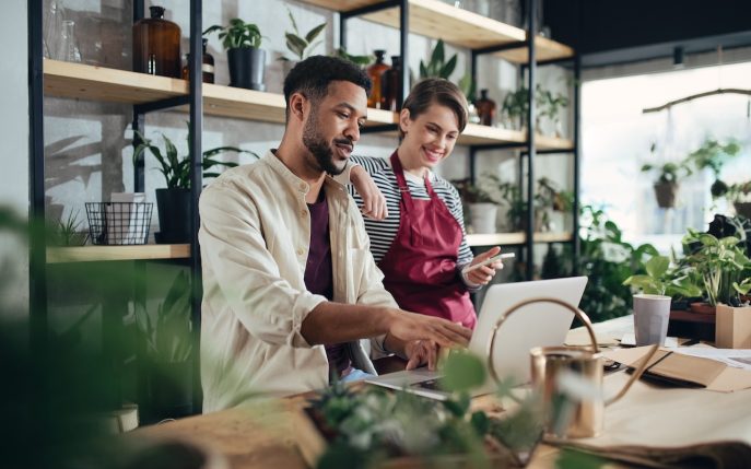 Two small business owners reviewing finances together in a plant shop