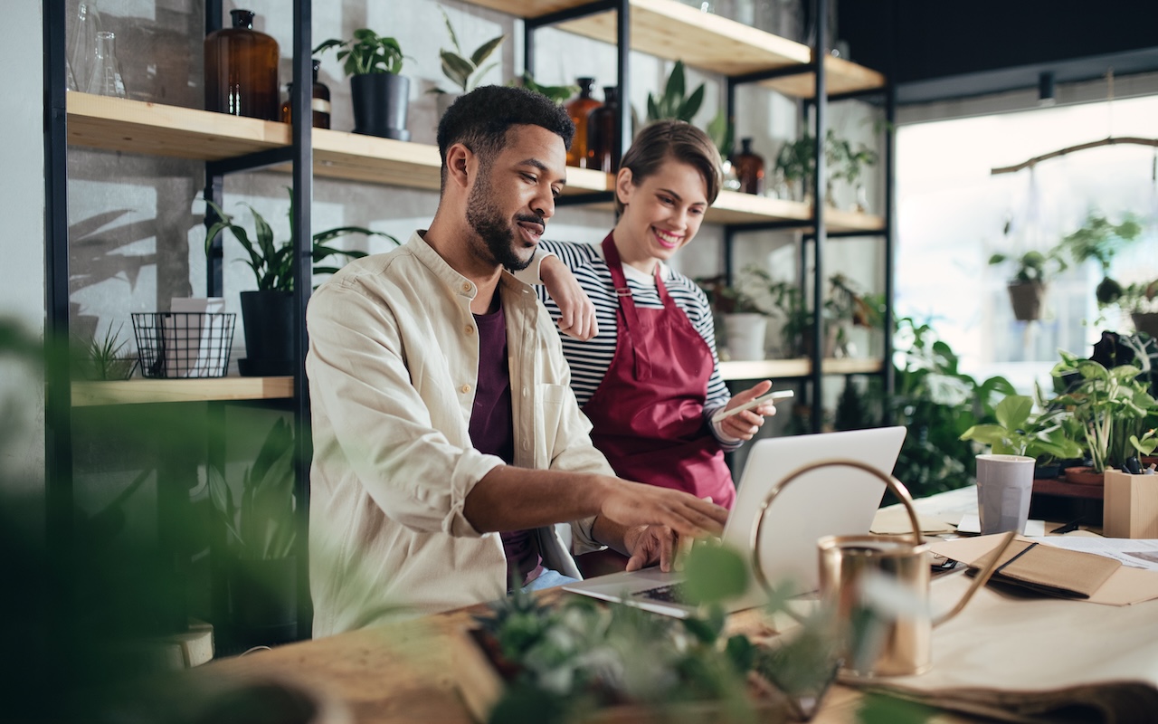 Two small business owners reviewing finances together in a plant shop