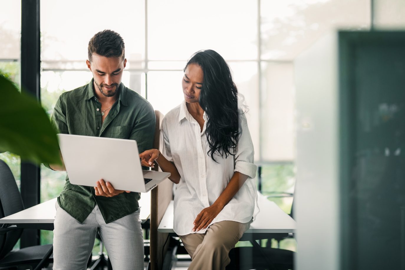 Two entrepreneurs collaborating over a laptop in a modern office