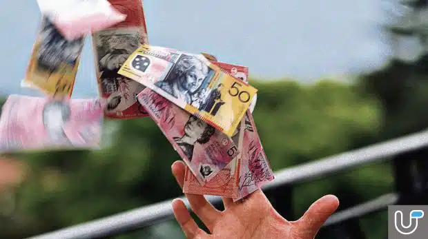 Australian banknotes falling from a person's hand, symbolizing financial loss