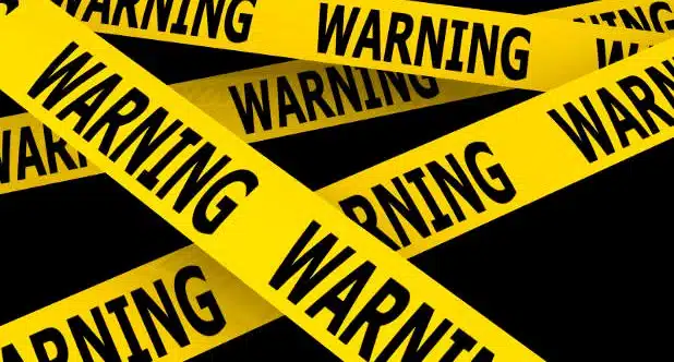 Yellow warning tape repeatedly marked “WARNING” on a black background