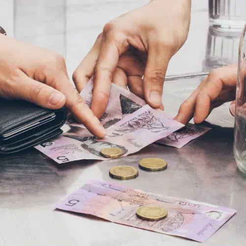 Hands exchanging Australian currency on a table