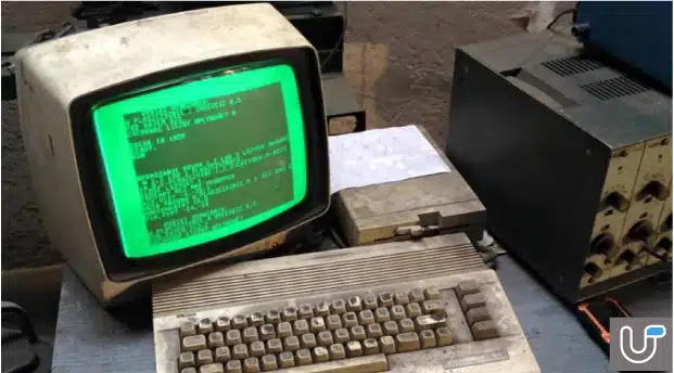 Old computer with green monochrome monitor displaying code, representing outdated technology