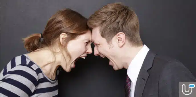 Angry couple shouting at each other with foreheads touching