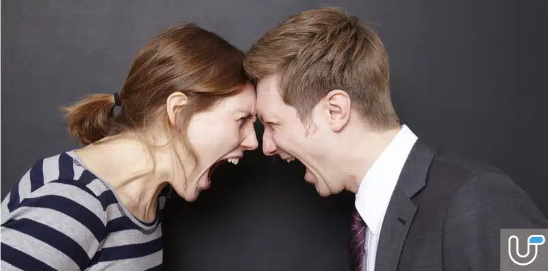 Angry couple shouting at each other with foreheads touching