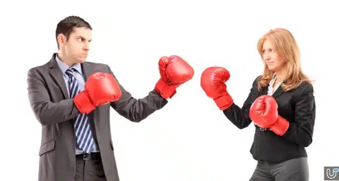 Businessman and businesswoman facing off in boxing gloves