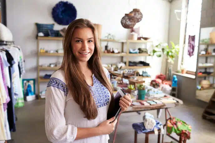 Female boutique owner standing with a tablet inside her retail store