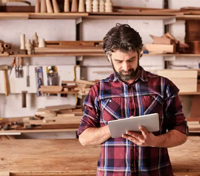 Man using a tablet in a woodworking shop