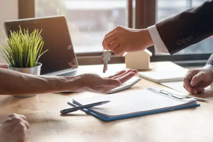 Close-up of a businessperson handing over keys during a contract signing