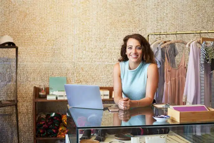 Smiling boutique owner standing confidently in a stylish retail store