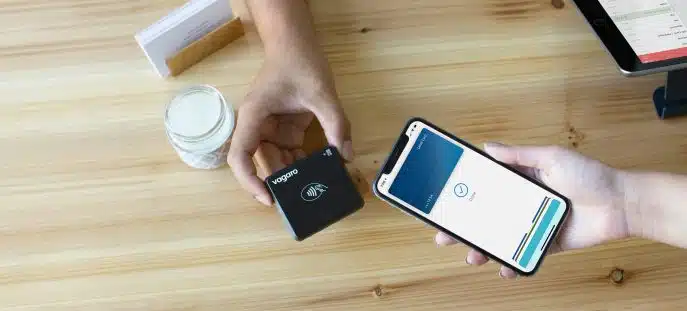 Customer making a contactless payment using a smartphone and a Vagaro card reader.