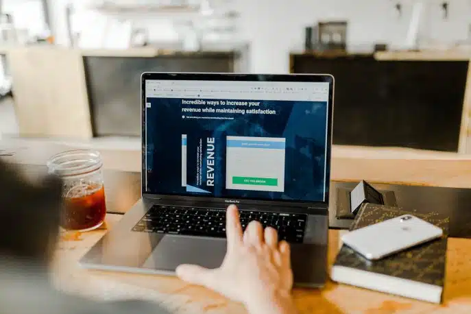Person browsing a marketing website on a laptop with ebook download form visible.