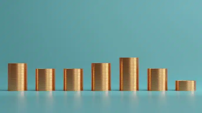 Stacks of gold coins arranged in varying heights on a blue background.