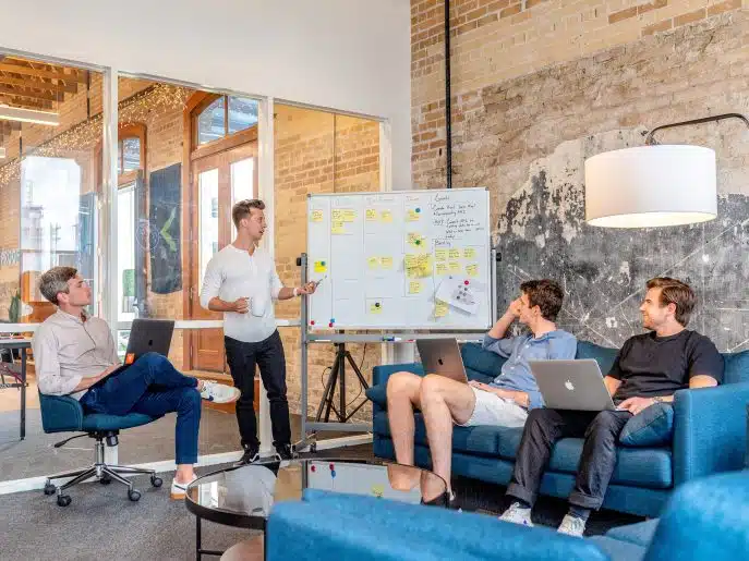 Team collaborating around a whiteboard in a modern office setting.