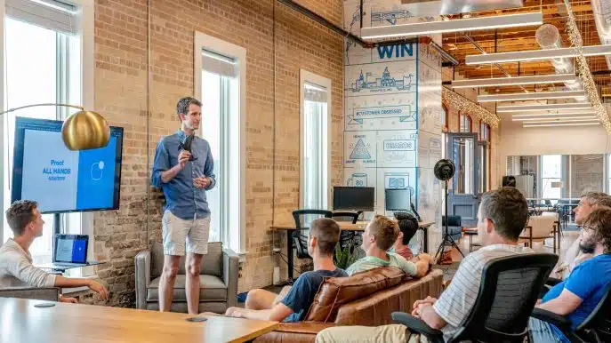 Man giving a presentation to a team in a modern office space