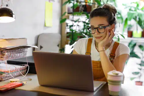 Smiling woman celebrating while managing her online retail business from home