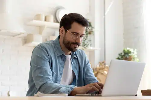 Man using laptop to submit an online loan application from home
